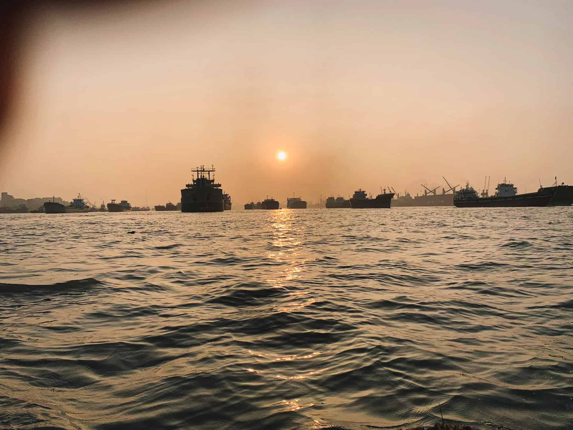 Cargo Ships and Waves in Karnaphuli River in Chittagong during sunset