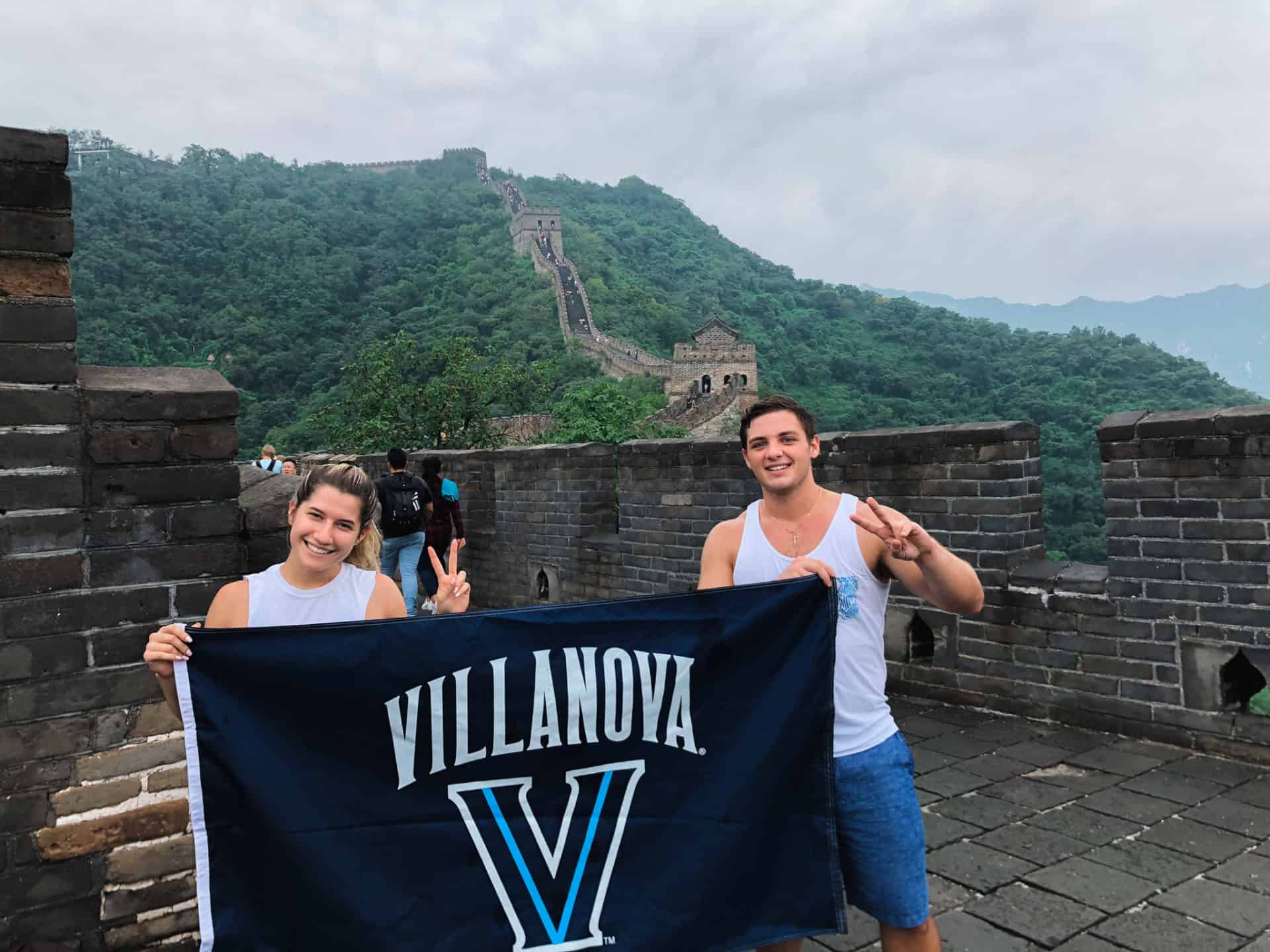 college students at the great wall of china holding a villanova university flag