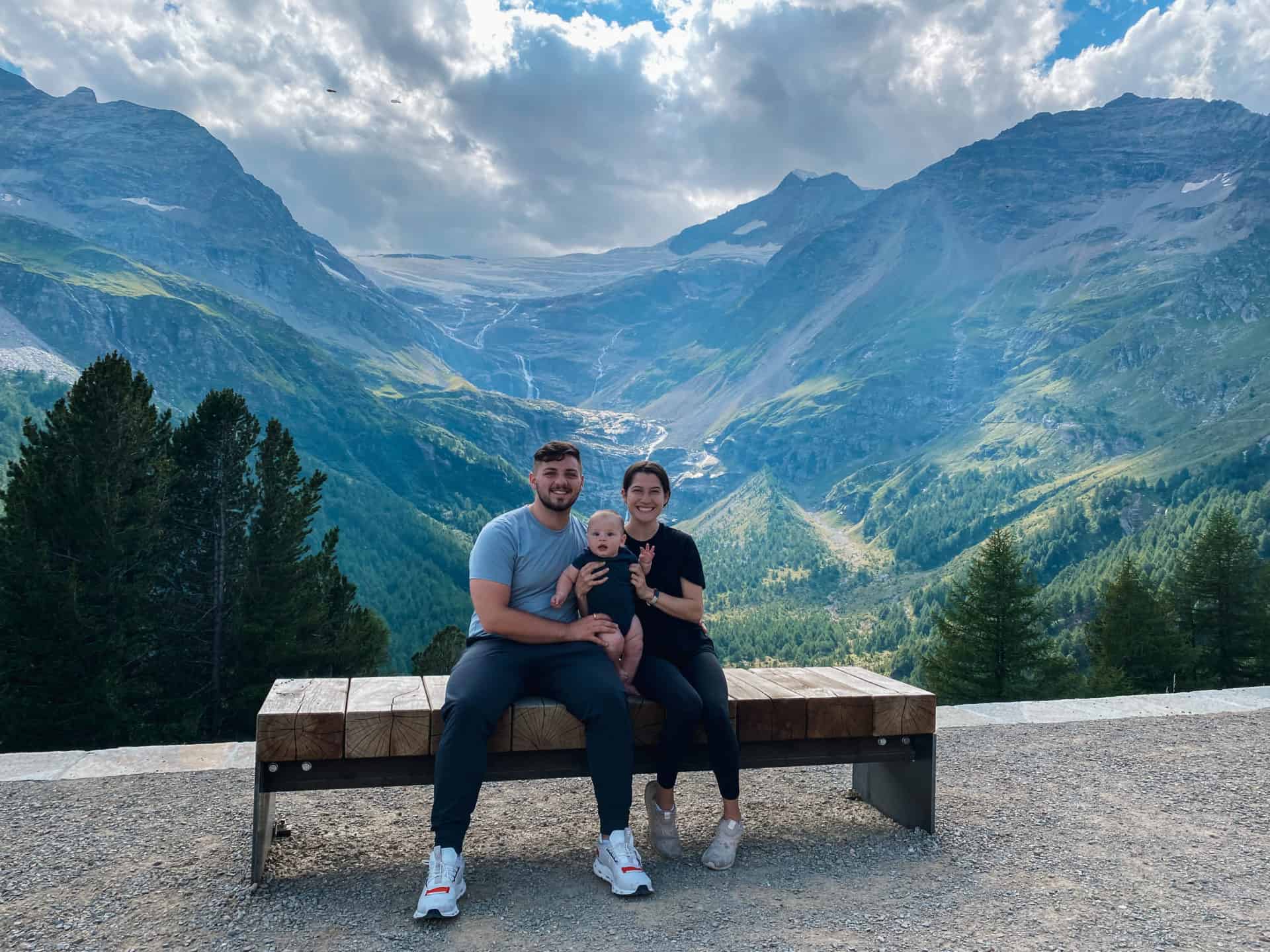 Happy family with a baby exploring the swiss alps on the bernina express train