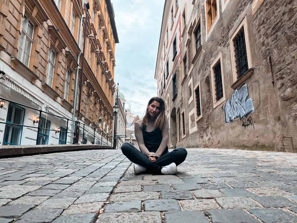 Cute American girl sitting on a street in Vienna