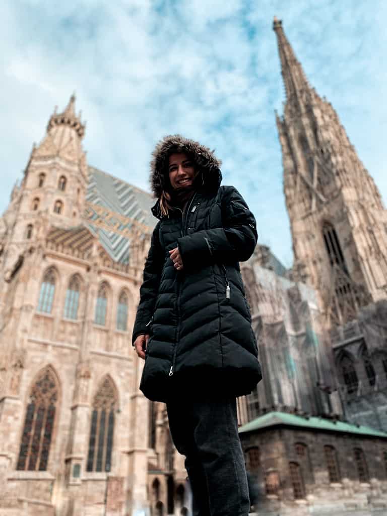 woman in black coat posing in front of St. Stephen's cathedral in Vienna