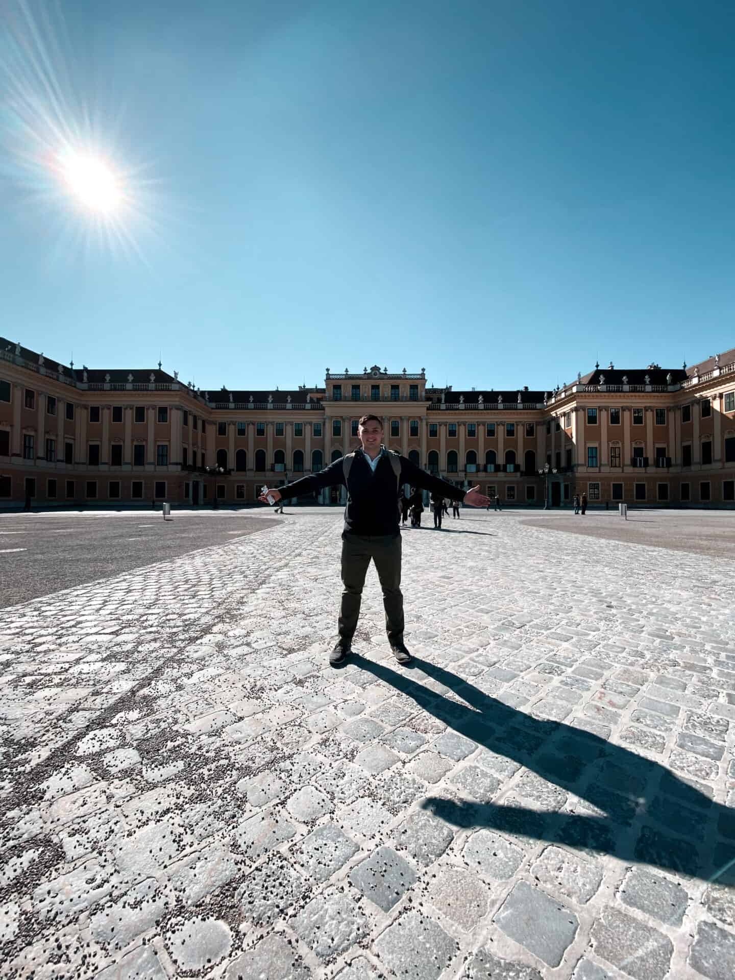 man standing in front european palace