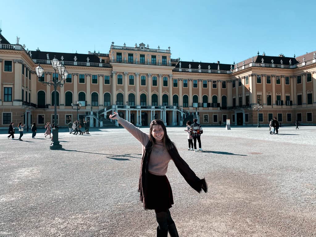 Beautiful American woman posing in front of Schonbrunn Palace in Vienna