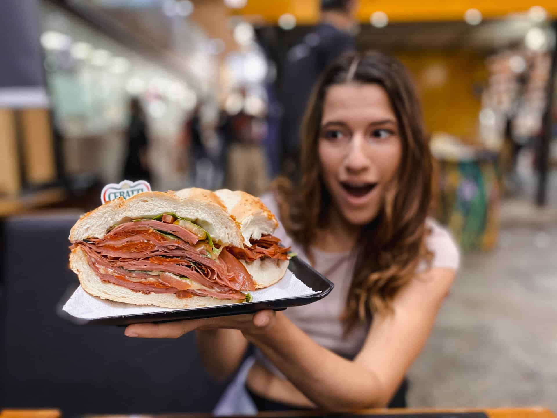 woman holding a massive sandwich in sao paulo brazil