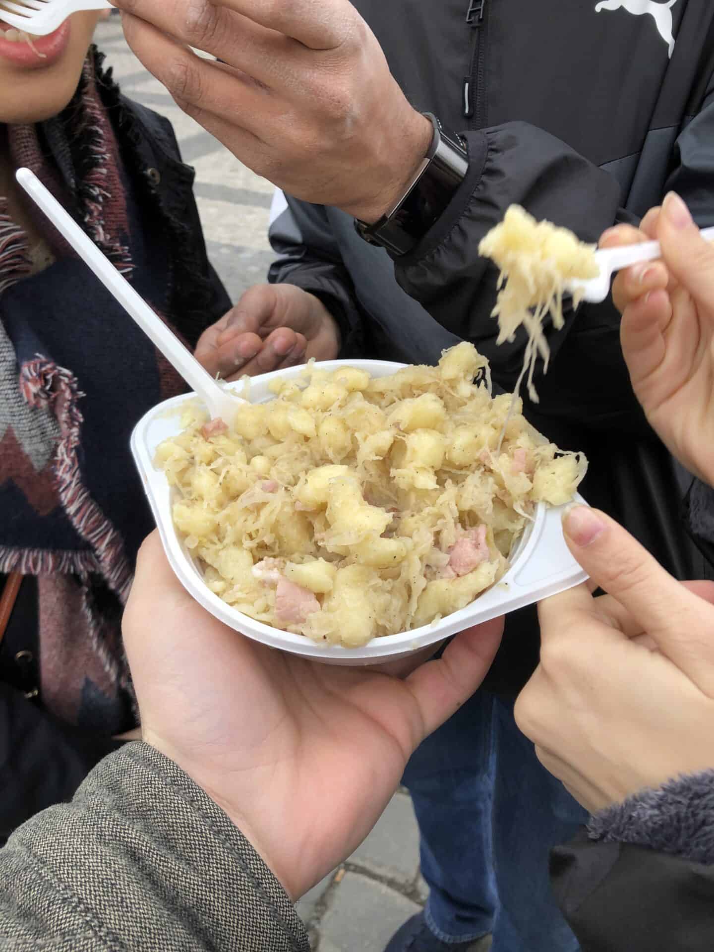 Group of friends eating from a big bowl of halusky 