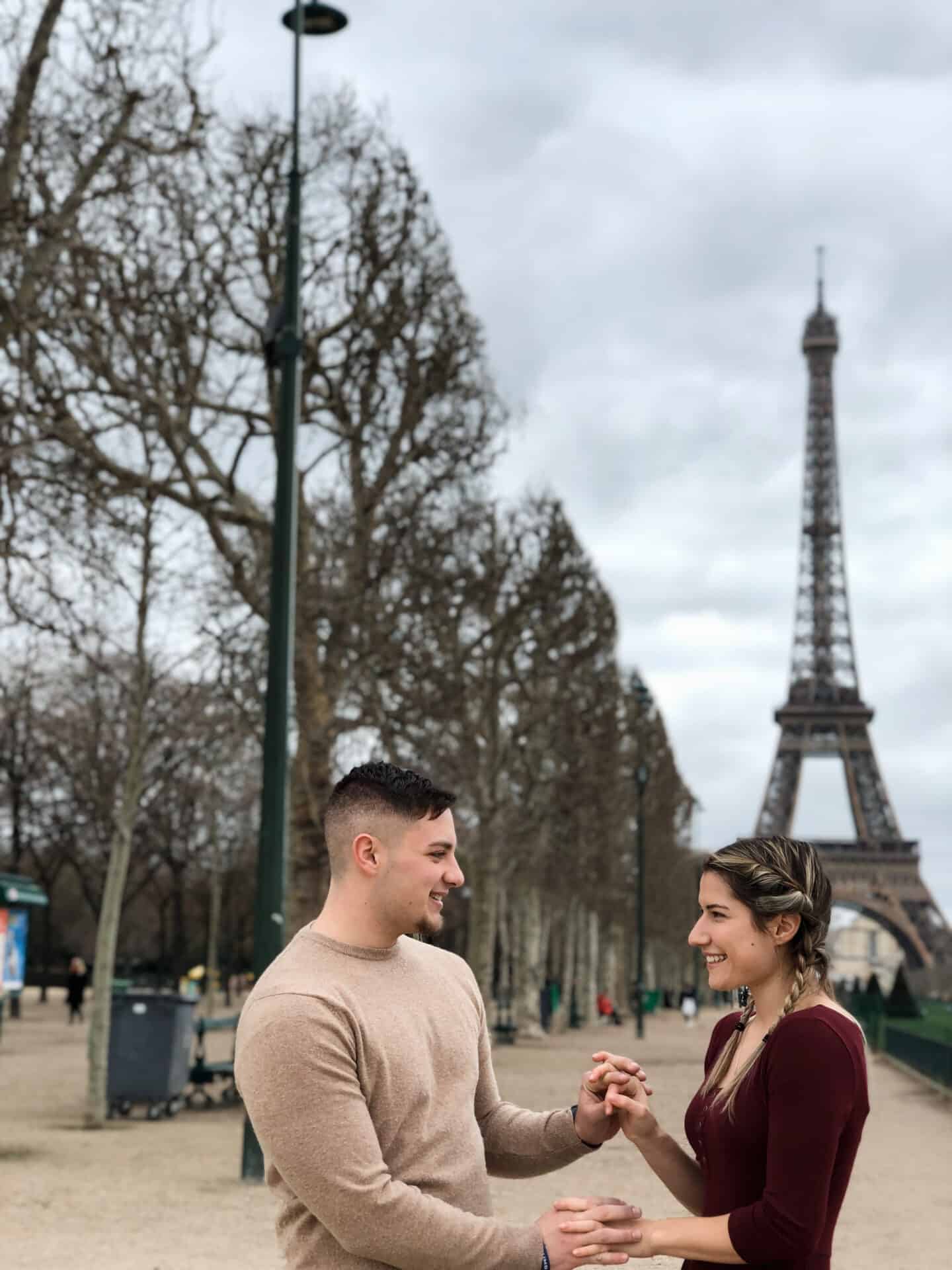 Couple holding hands at Eiffel Tower in Paris
