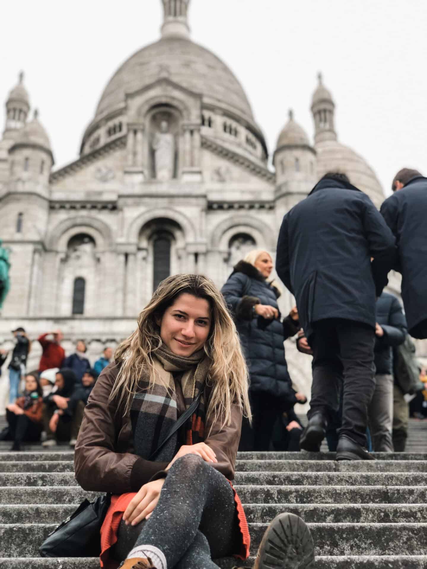 Beautiful woman sitting on the Sacre Coeur Basilica steps in Paris