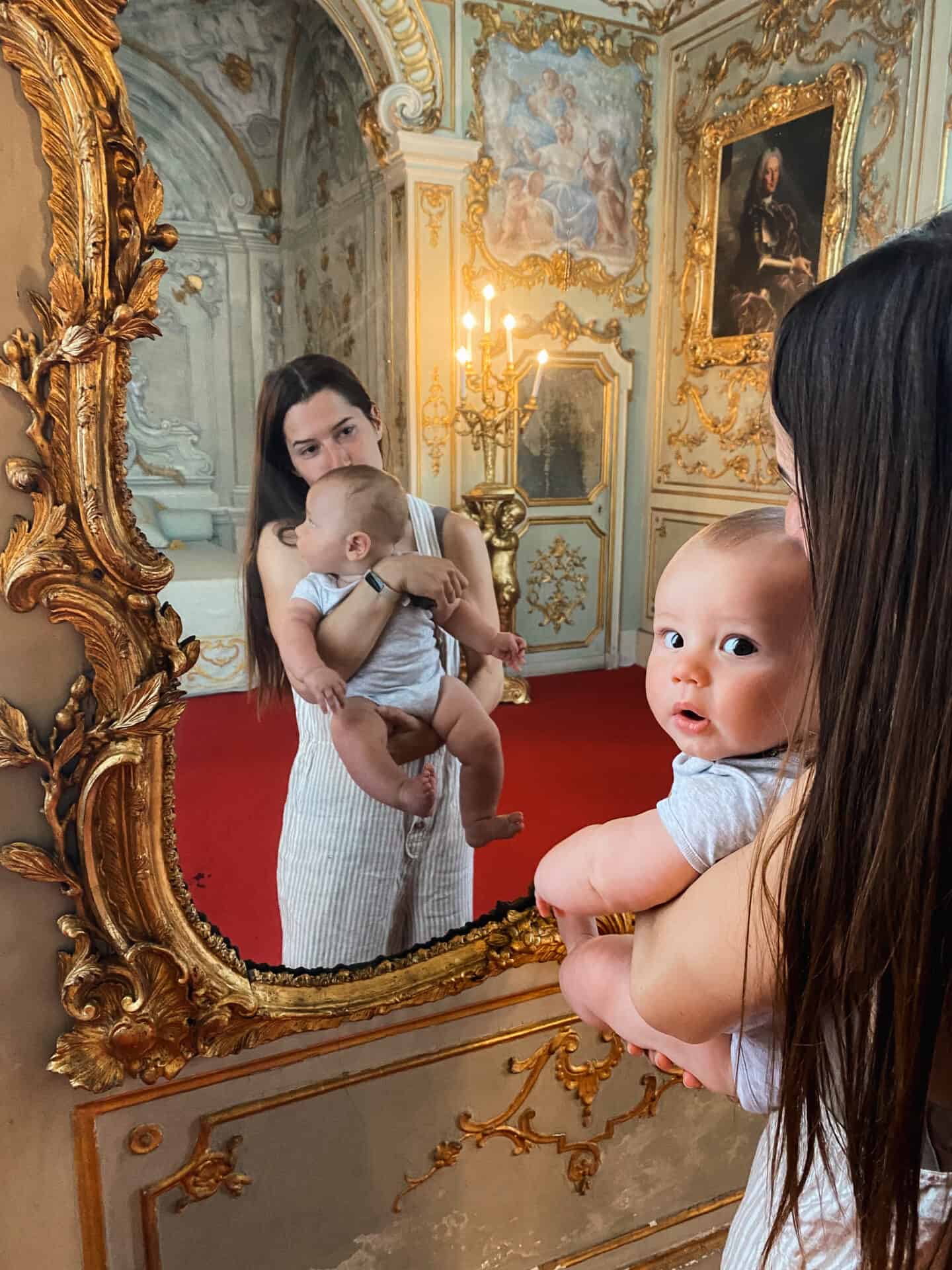 baby and mother looking and magnificent royal mirror