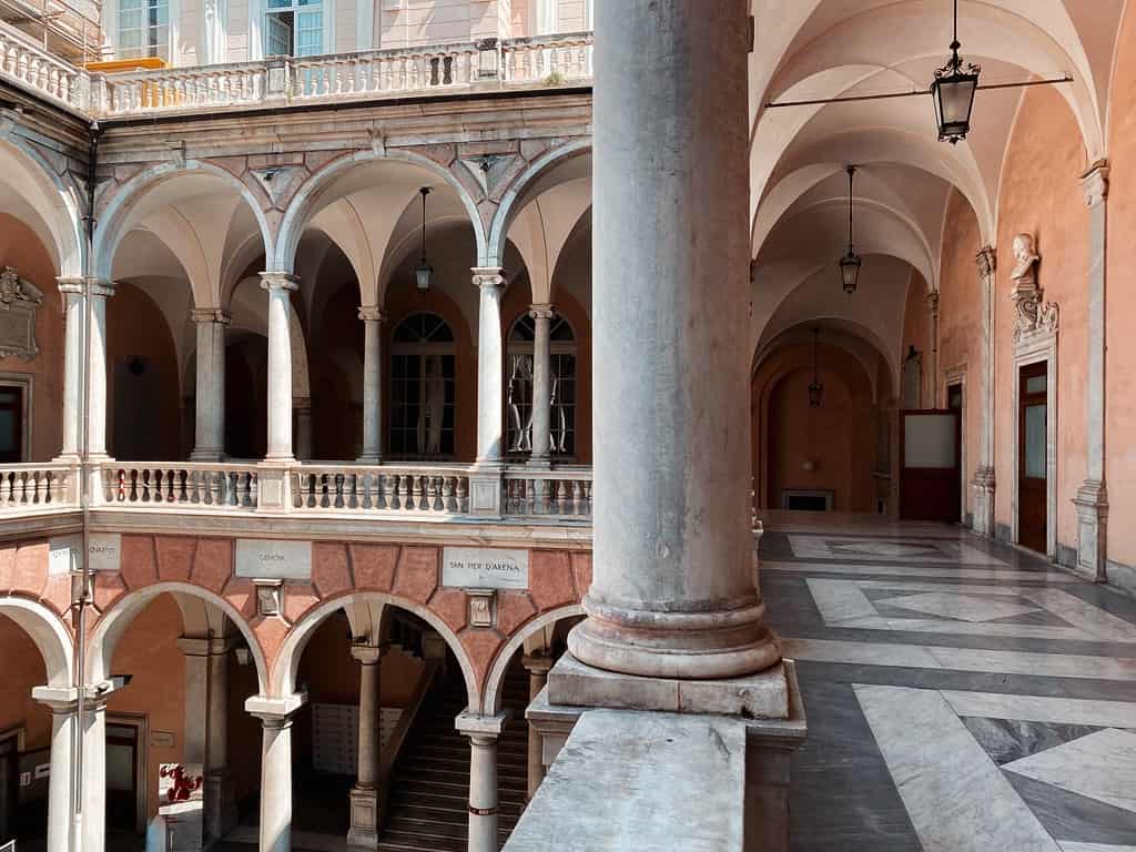 Columns and archways in a red stone museum in genoa italy