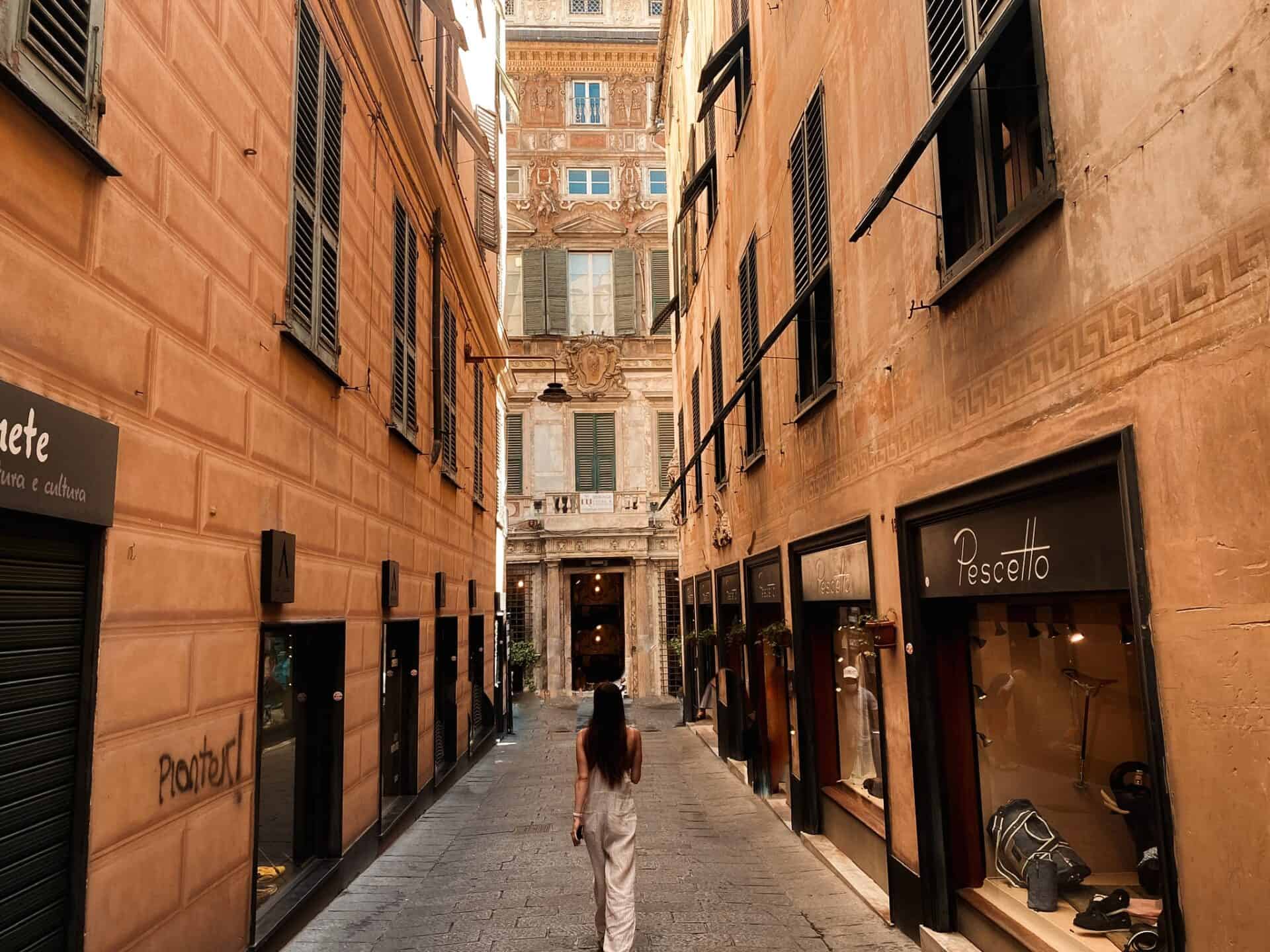 woman walking down long european pedestrian street in Genova Italy