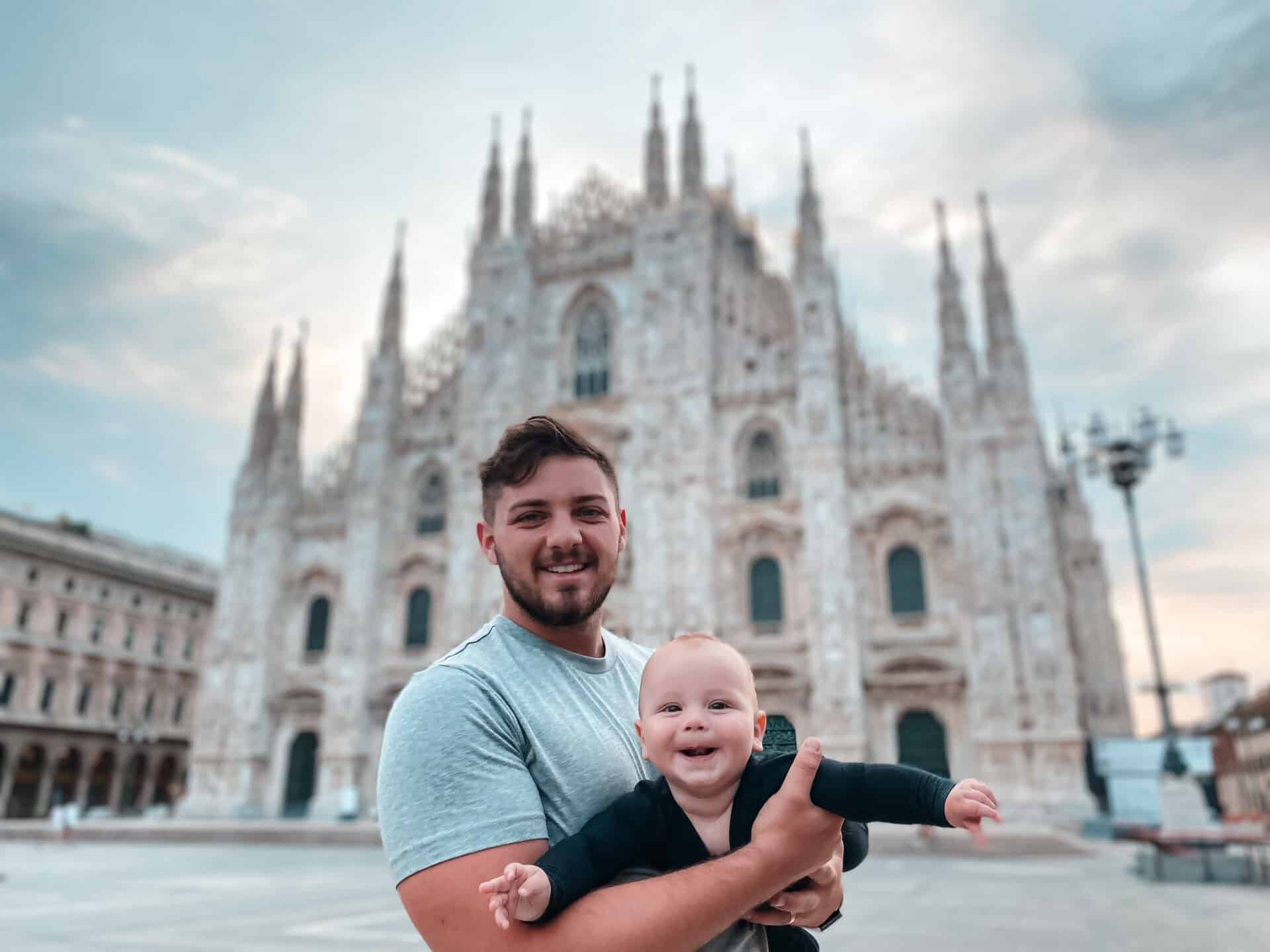 father holding baby son in front of Milano Dome