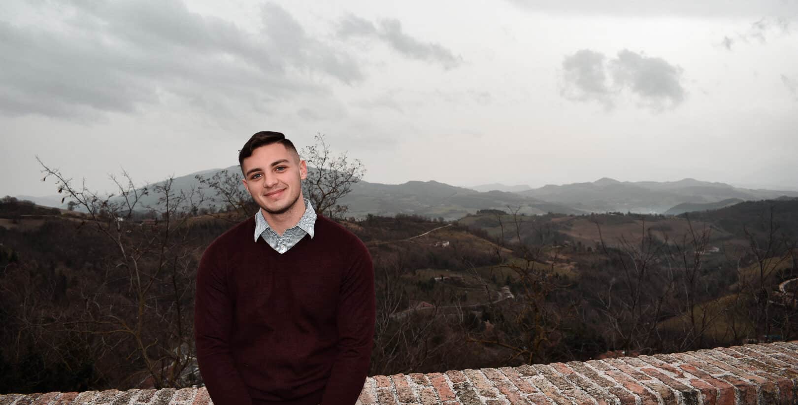 italian college student posing in front of Italian hills in urbino