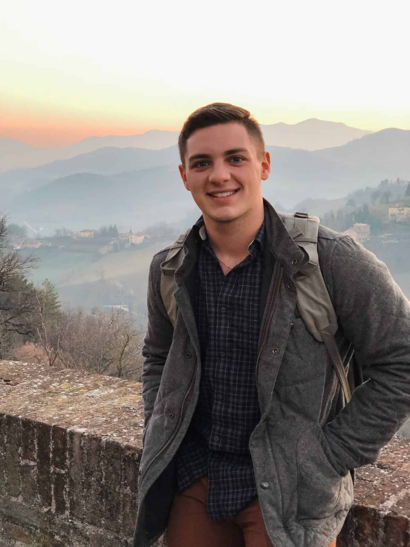 college boy with italian mountains during dawn