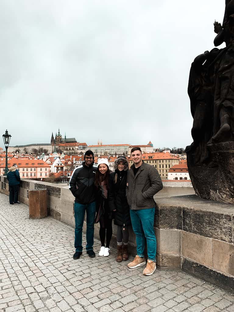 four friends standing on bridge during overcast day