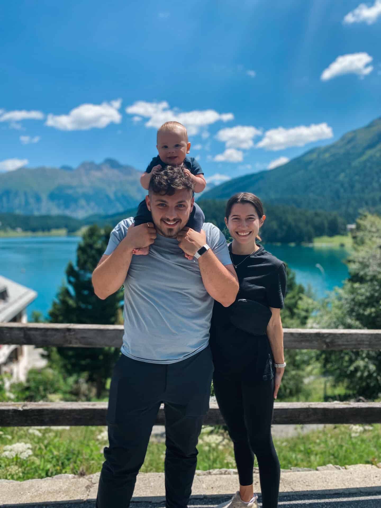 Family with a baby joyfully hiking by lake in St. Moritz Switzerland