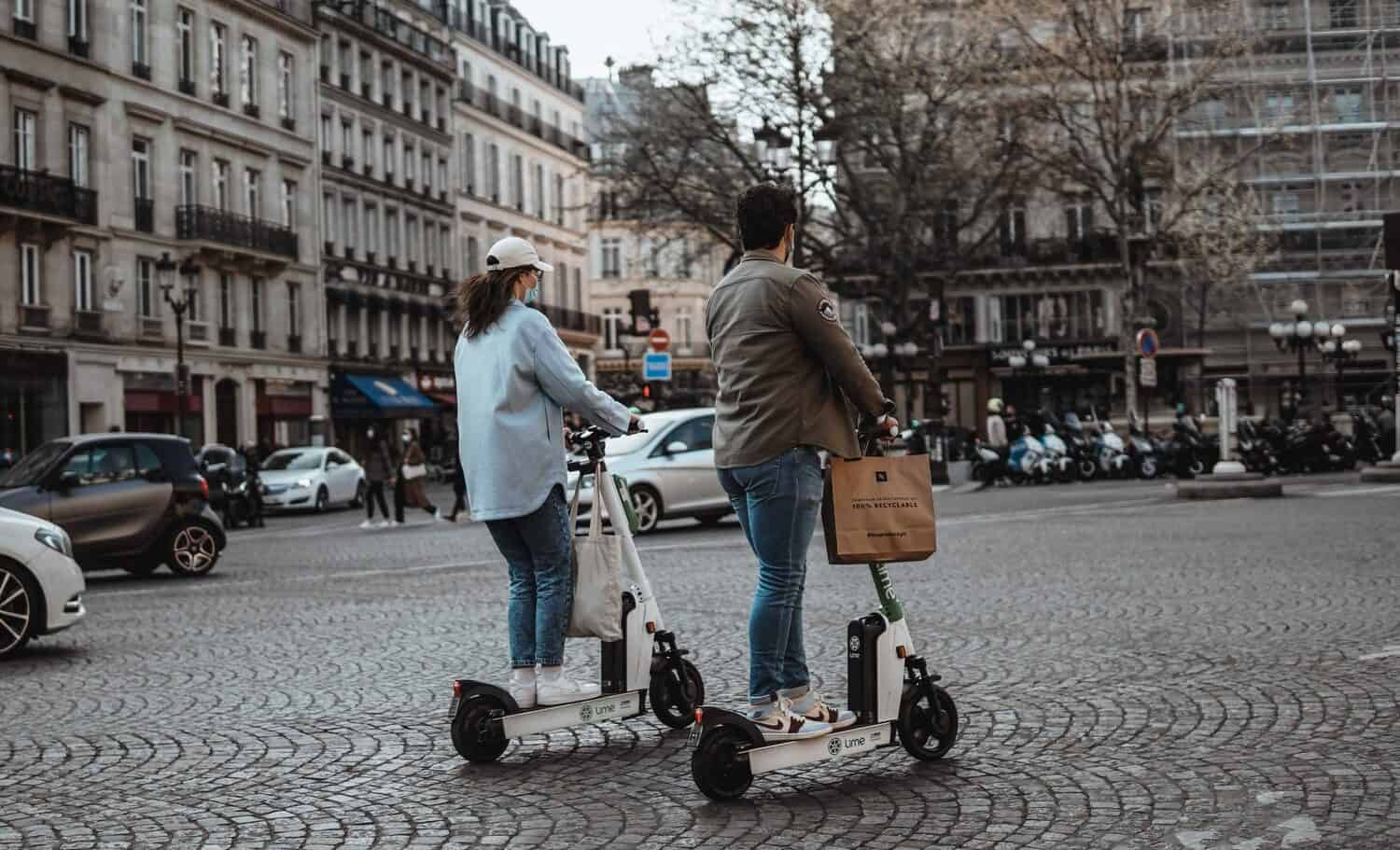 German man and woman riding white electric scooters