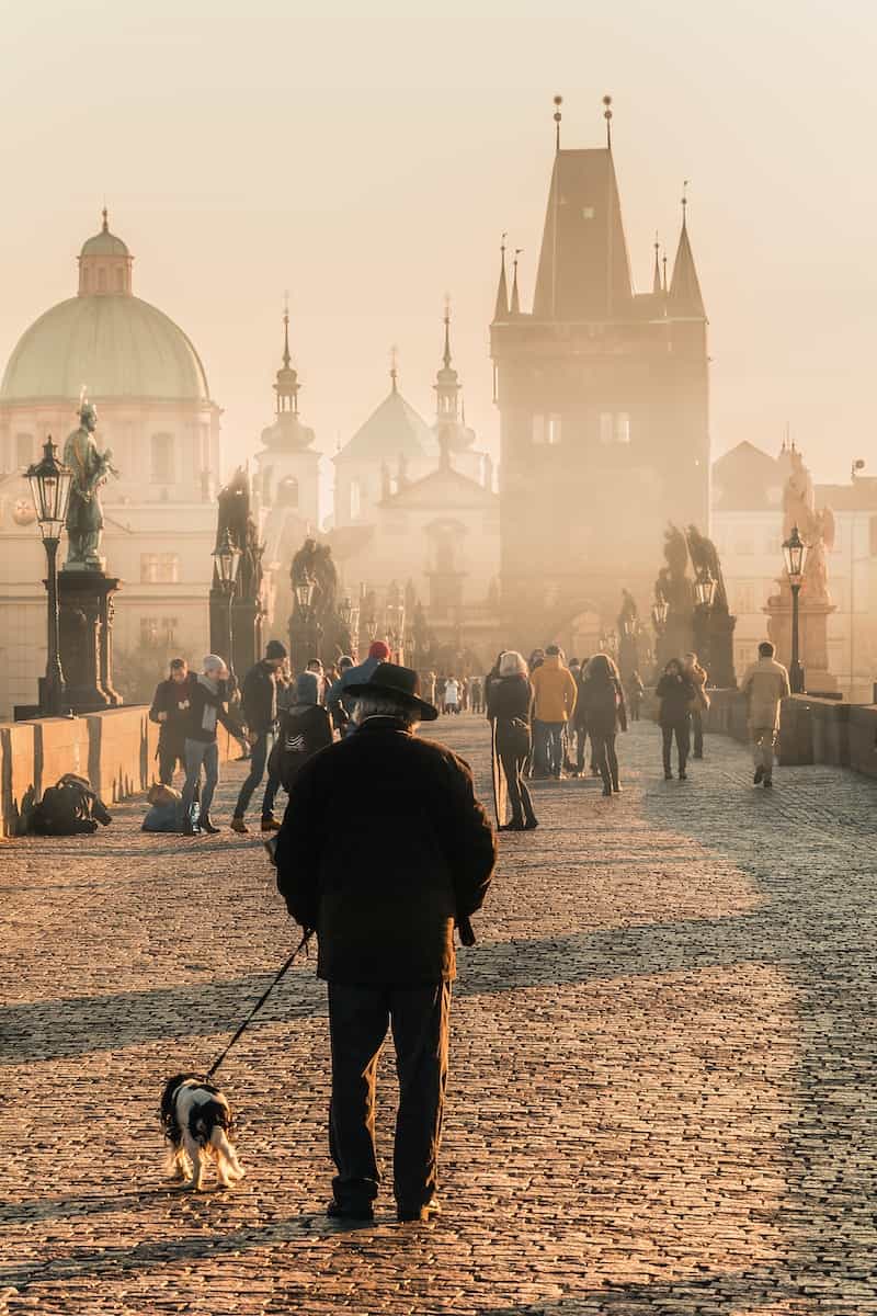 people walking on misty bridge near building during hazy daytime