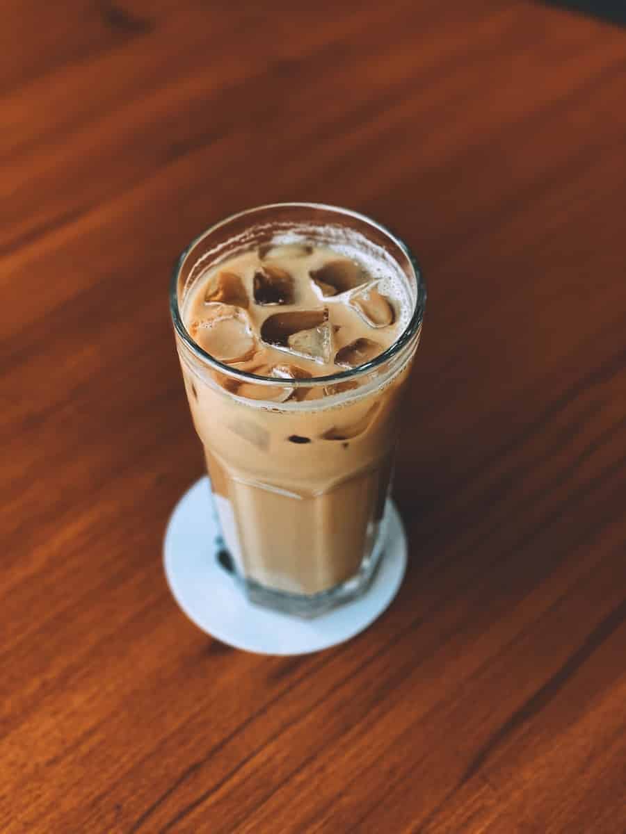 Iced latte in a glass on a chestnut table