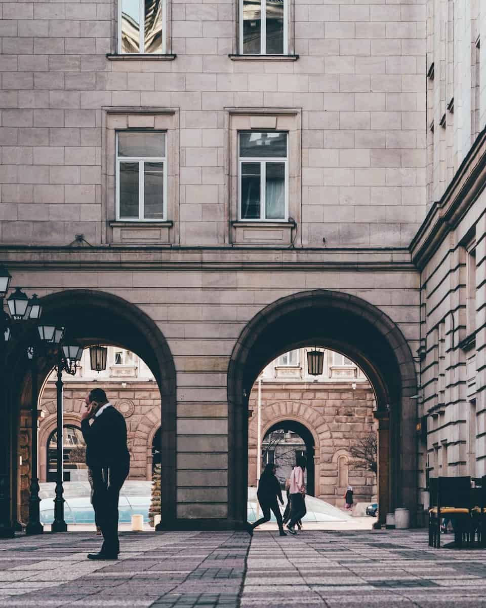 two classic beige archways with people walking through them