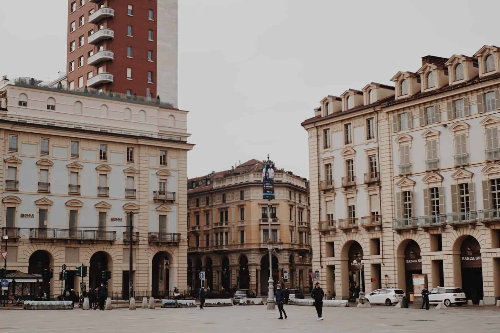 people walking on Turin street near brown concrete building during daytime