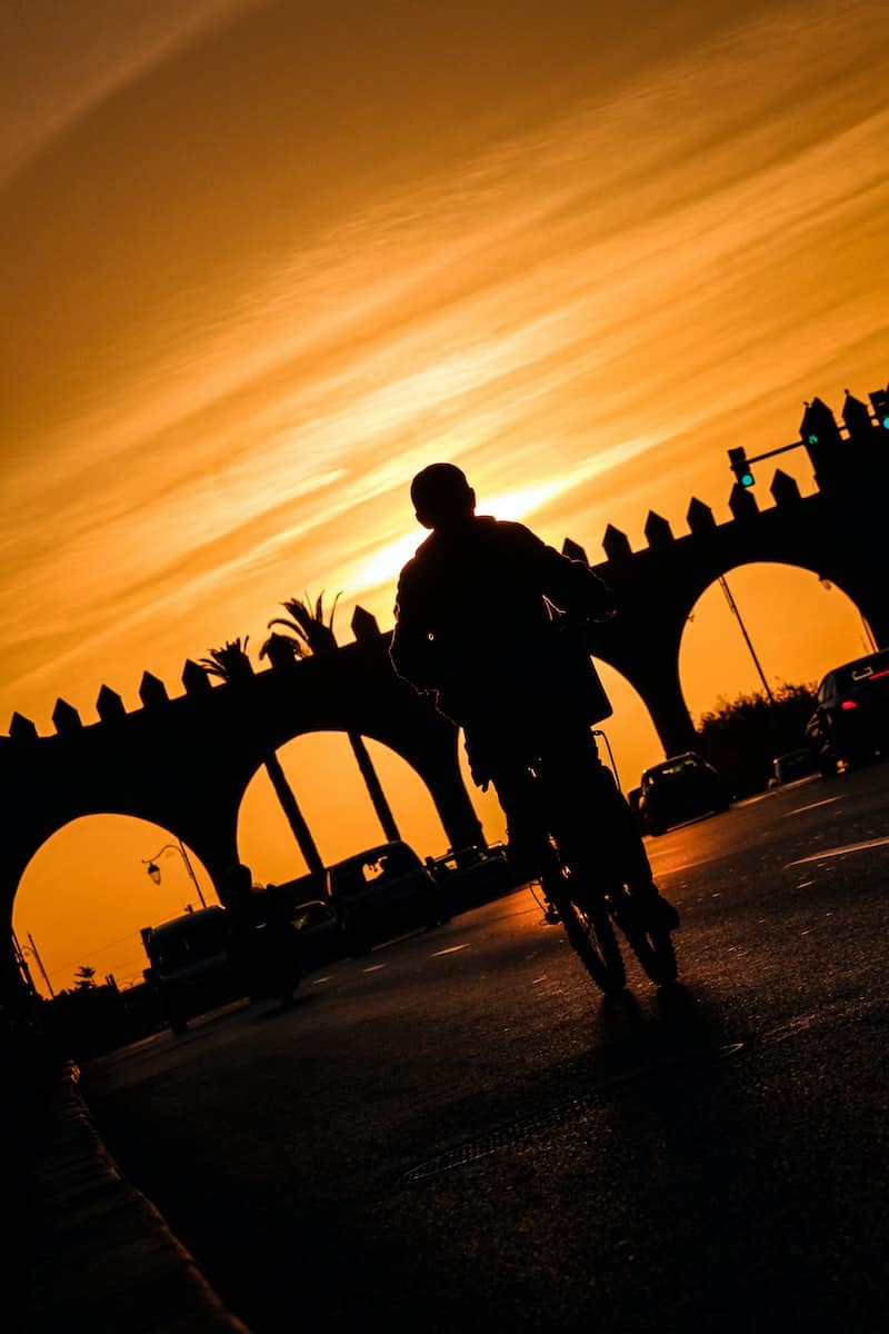 silhouette of man riding bicycle on rabat road during sunset