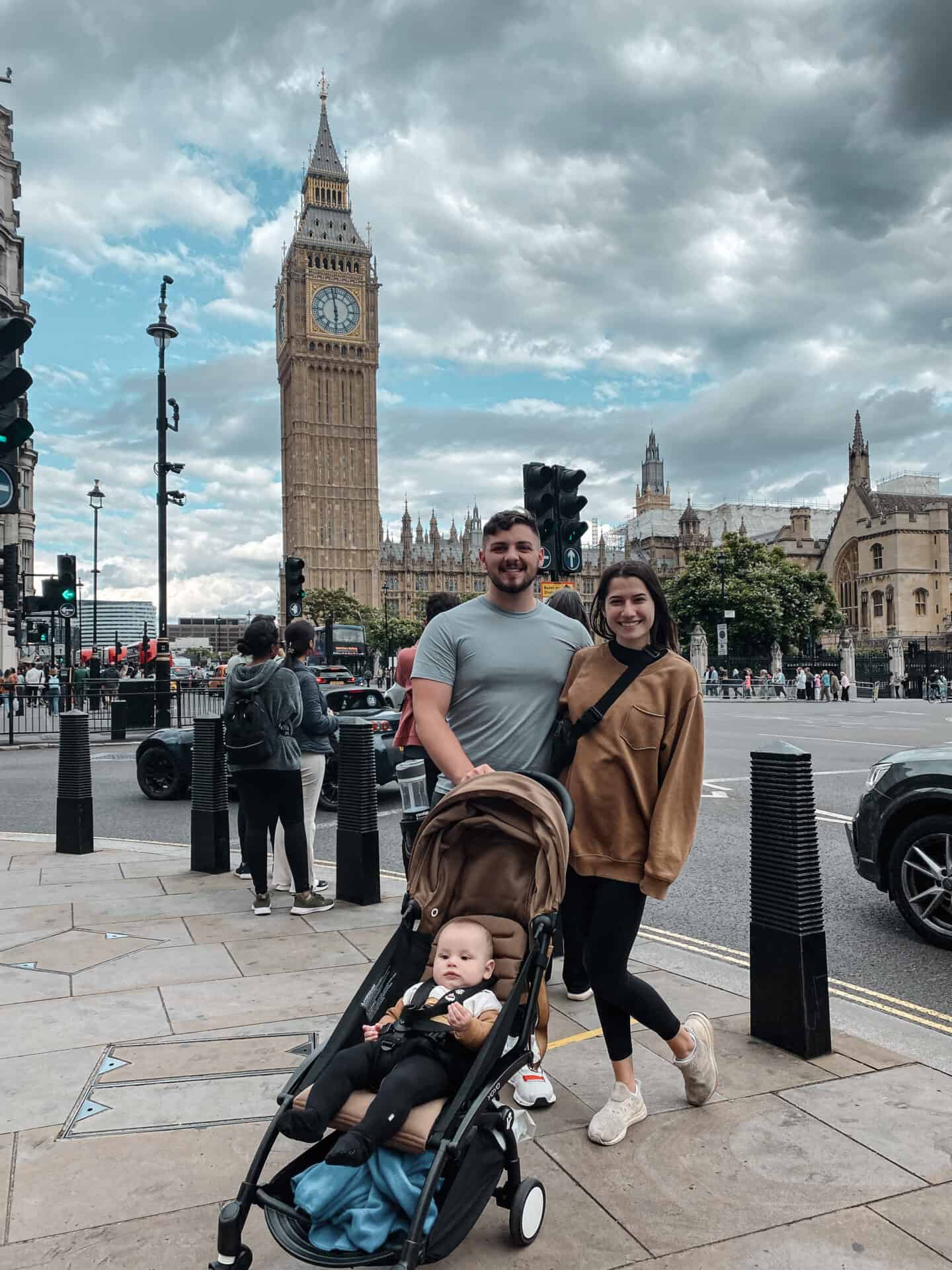 Family with baby in front of Big Ben and Westminster Abbey in London