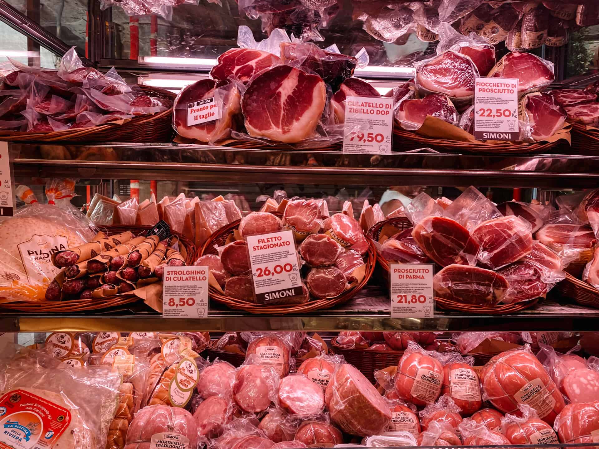 Butcher's window with rows of raw meat in Bologna Italy