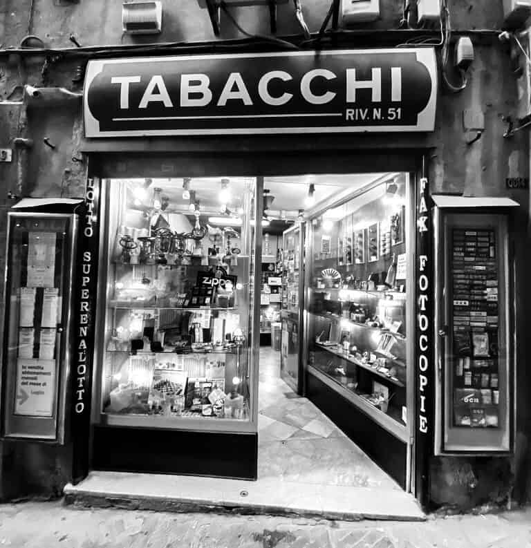 Black and white Tobacco Store Sign hanging from wall in Italy