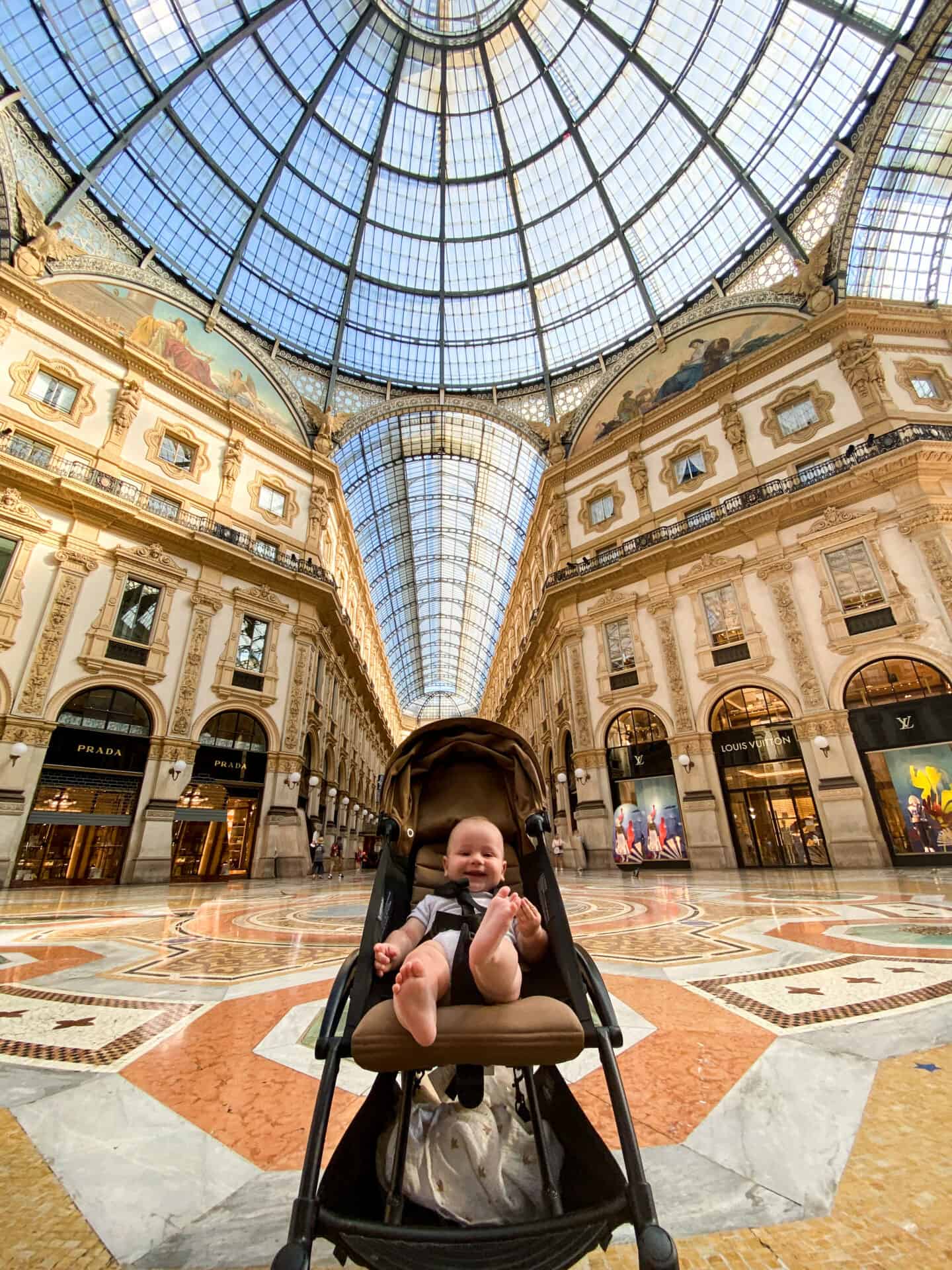 Adorable 6 month old baby smiling in stroller at Galleria early in the morning in milan