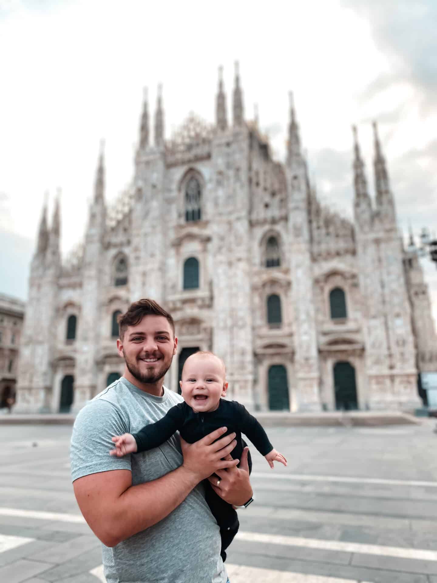 father holding baby son in front of Milano Dome
