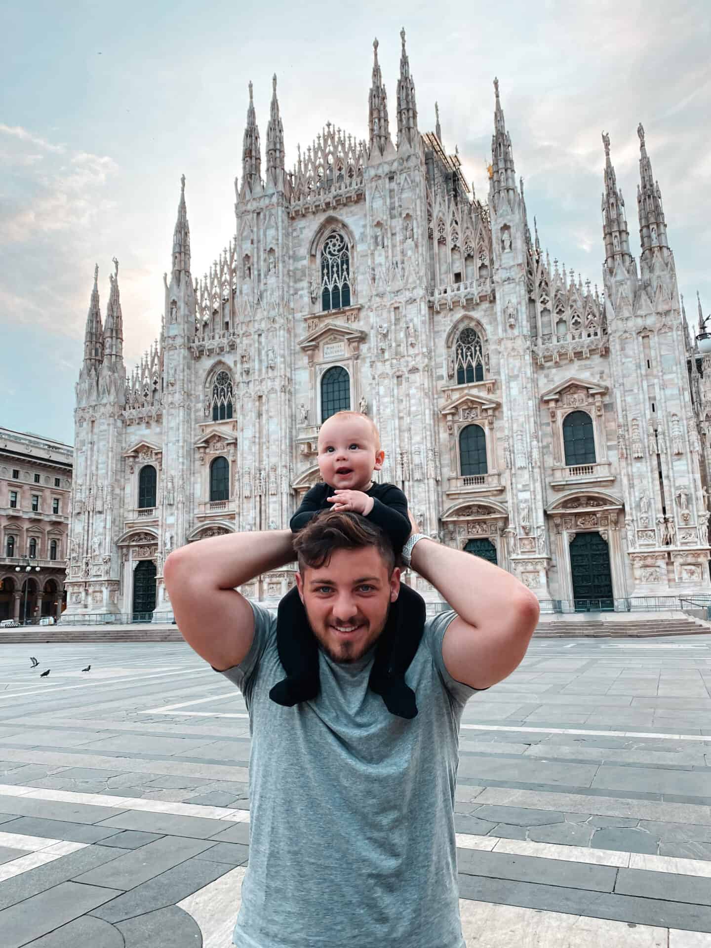 baby on fathers shoulders in front of Milano Duomo