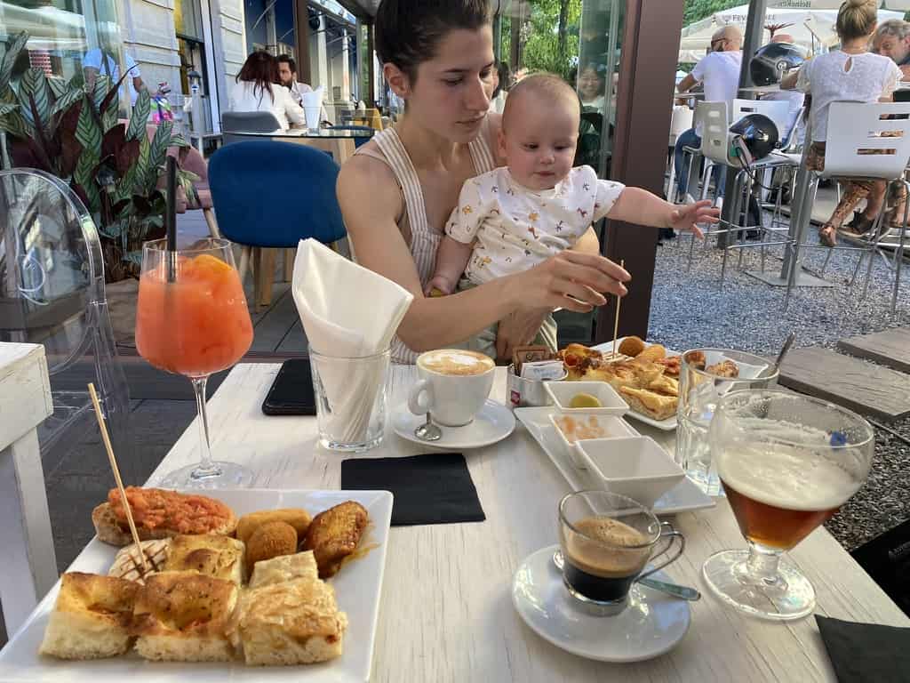 A restaurant table in the street of Milan filled with aperitivo snacks and drinks
