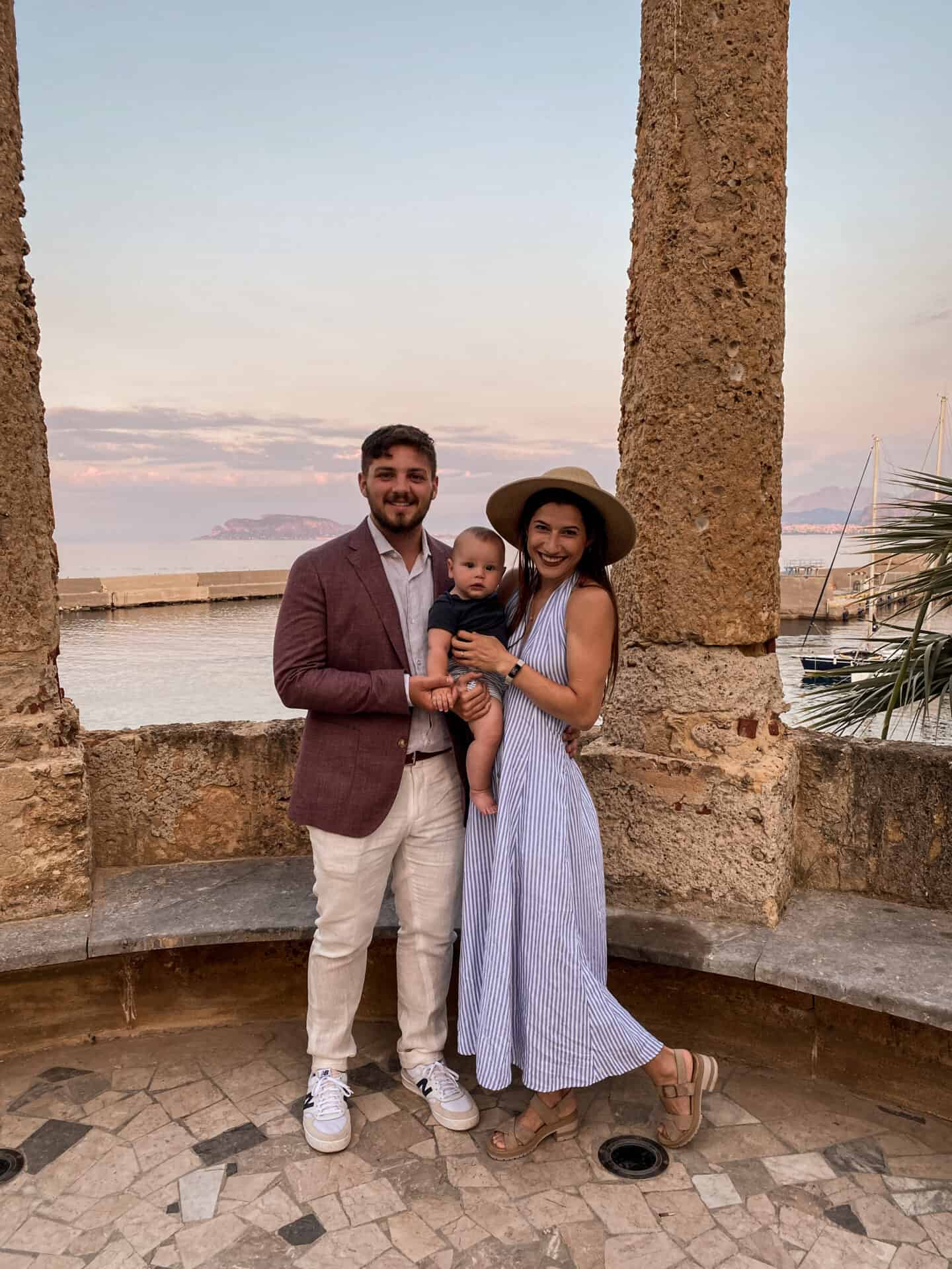 American family with baby posing under roman Columns at the port of Palermo