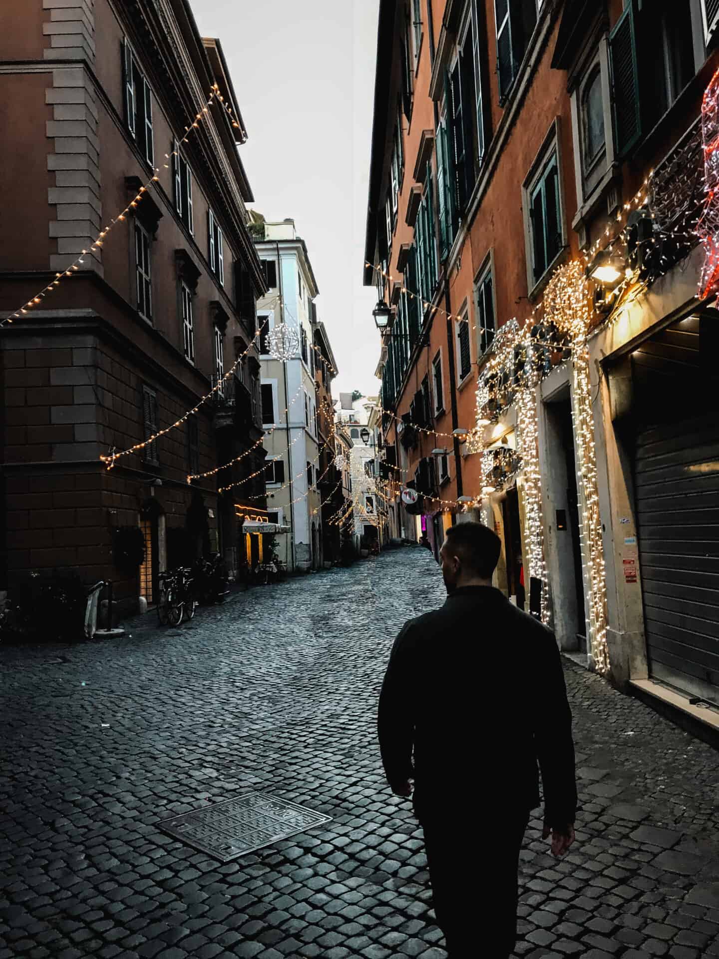man walking down moody street in Italy Rome