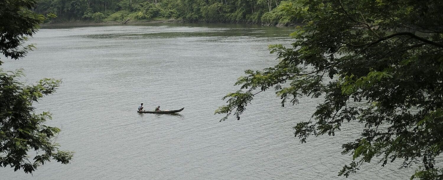 Man paddling canoe on a lake in Bangladesh