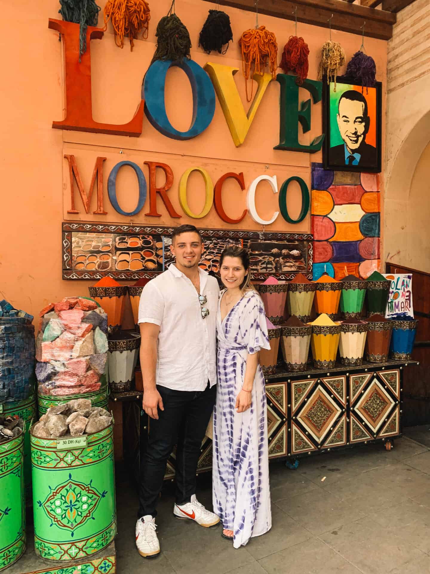 couple standing in front of I love Morocco sign