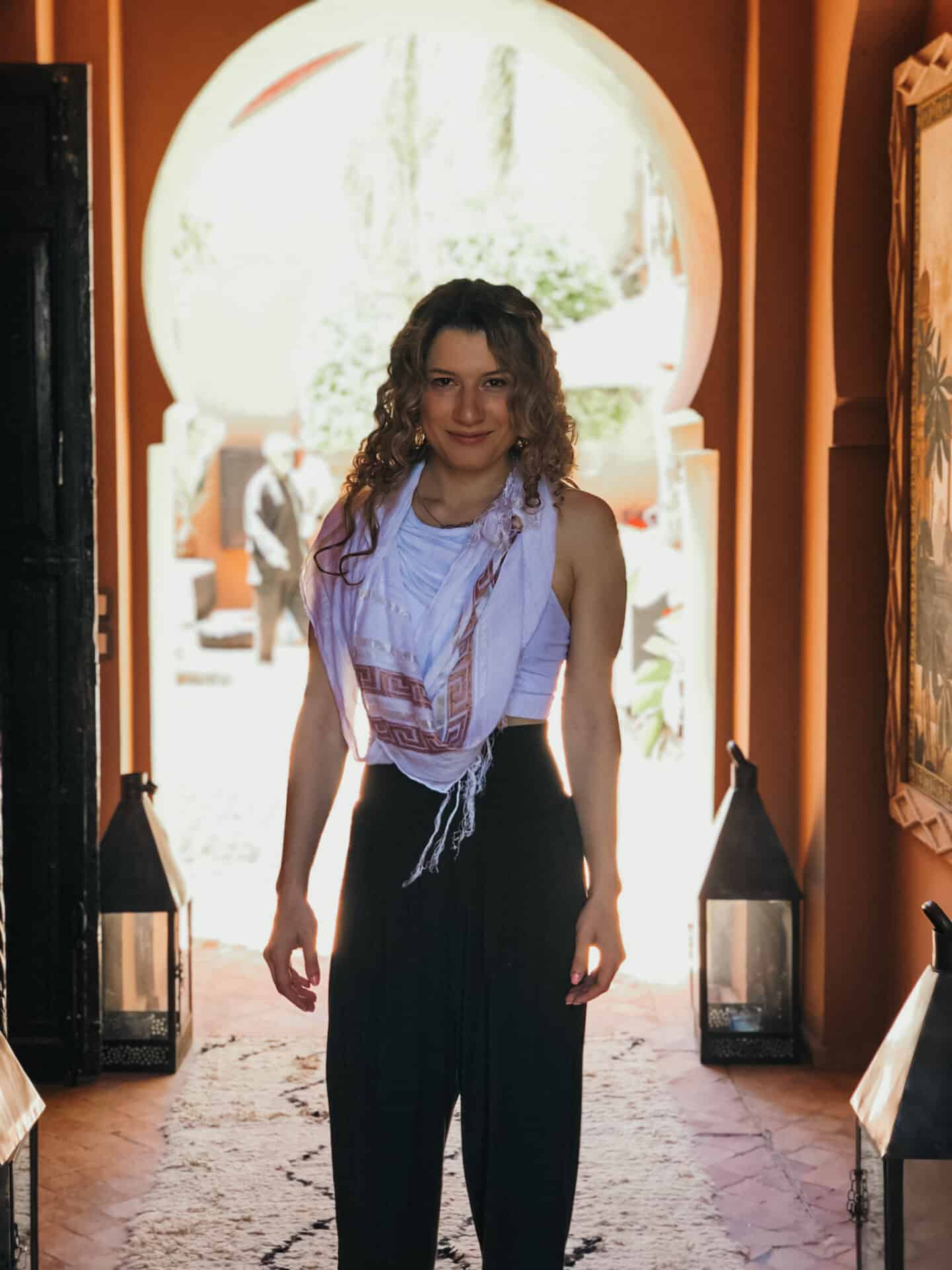 Woman standing in center of Moroccan archway in marrakech