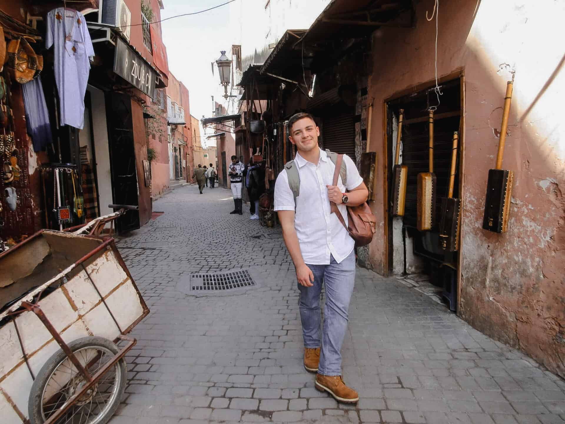 Young male traveler with backpack standing in Marrakesh Souk