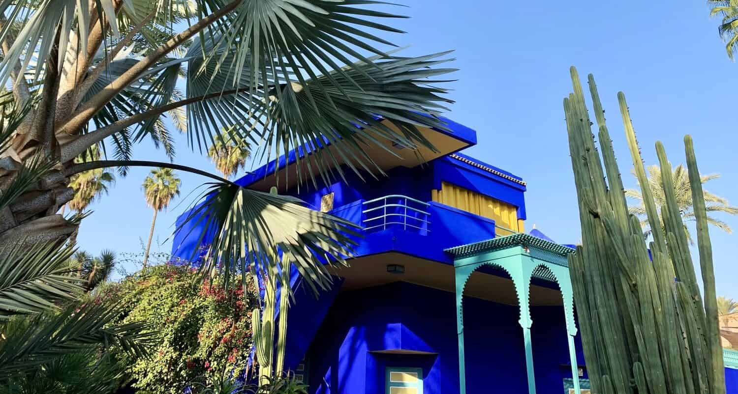 famous blue buildings in Majorelle Garden Morocco with palm trees