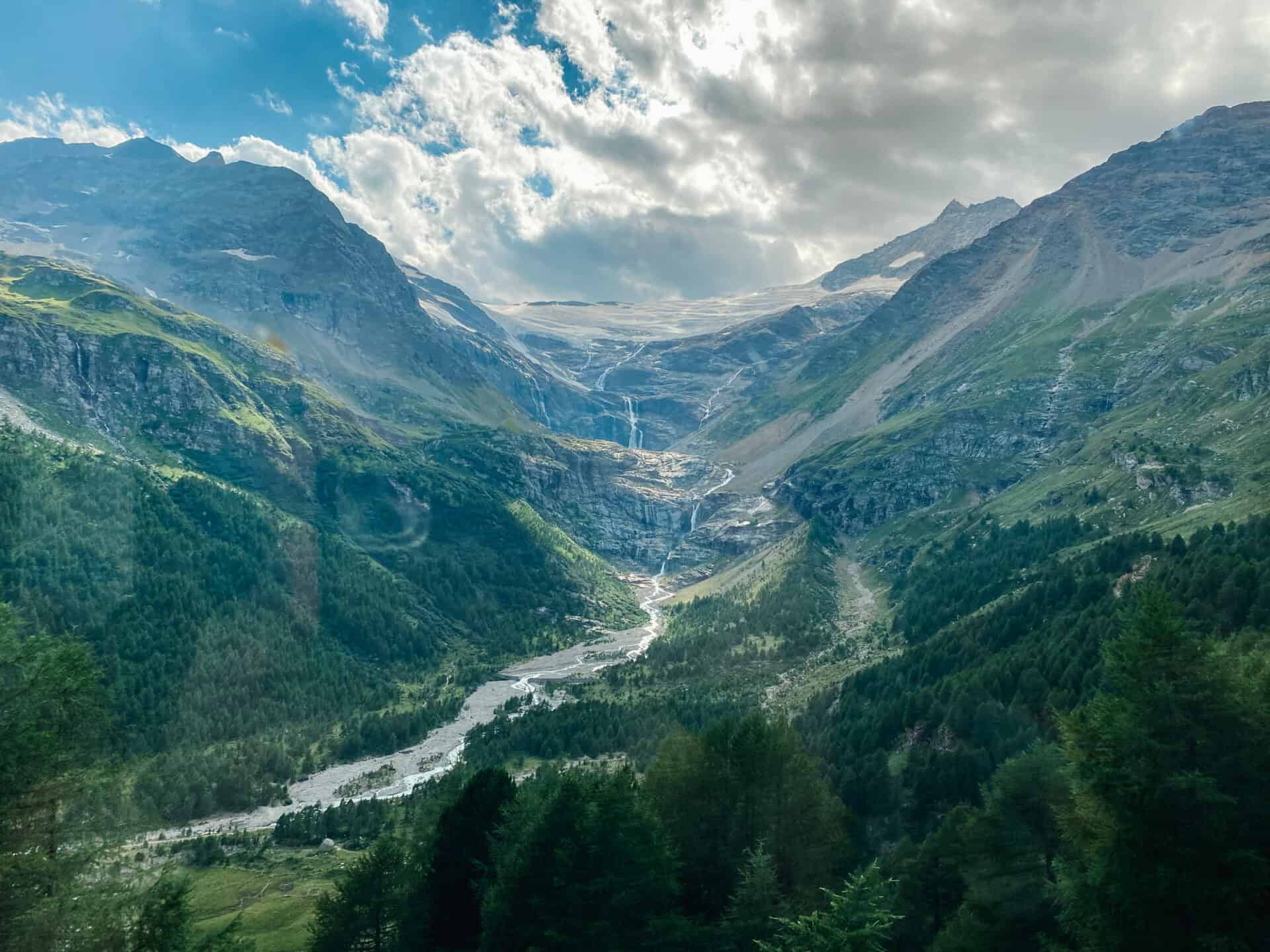 breathtaking view of swiss alps with waterfall and river from the bernina express train