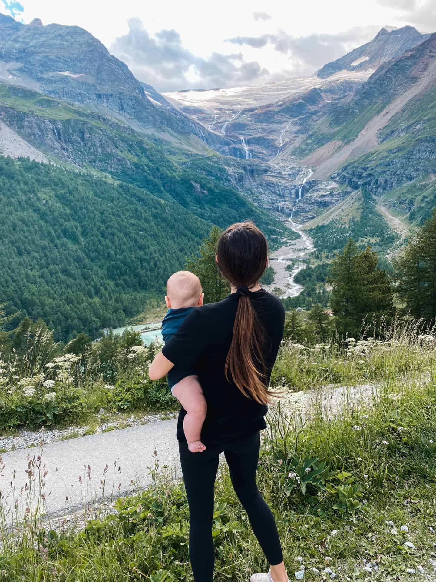 Mom with baby on hip admiring the Swiss Alps on Bernina Express