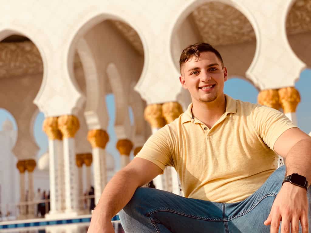 Man sitting in front of the Sheikh Zayed Grande Mosque in Abu Dhabi