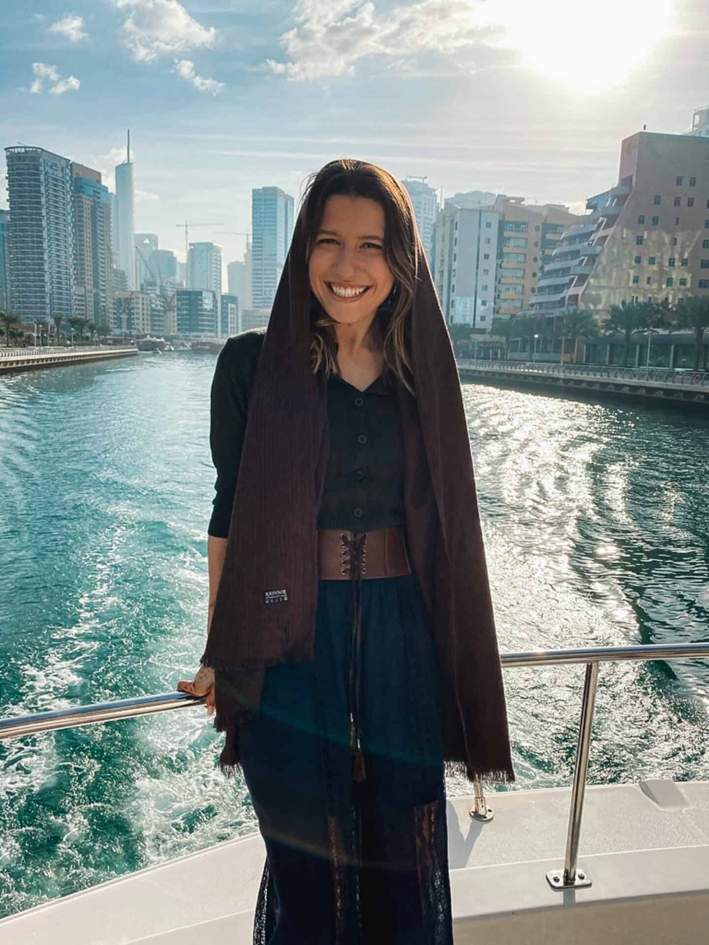 female model on yacht in Dubai marina with city skyline in the background