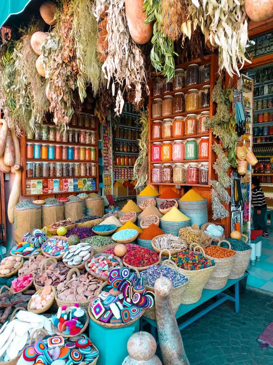 assorted color of wicker baskets with spices on display in souk of Marrakech