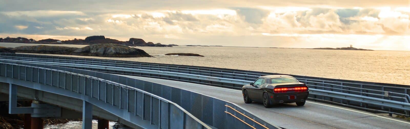 black suv on gray concrete bridge under gray cloudy sky during daytime