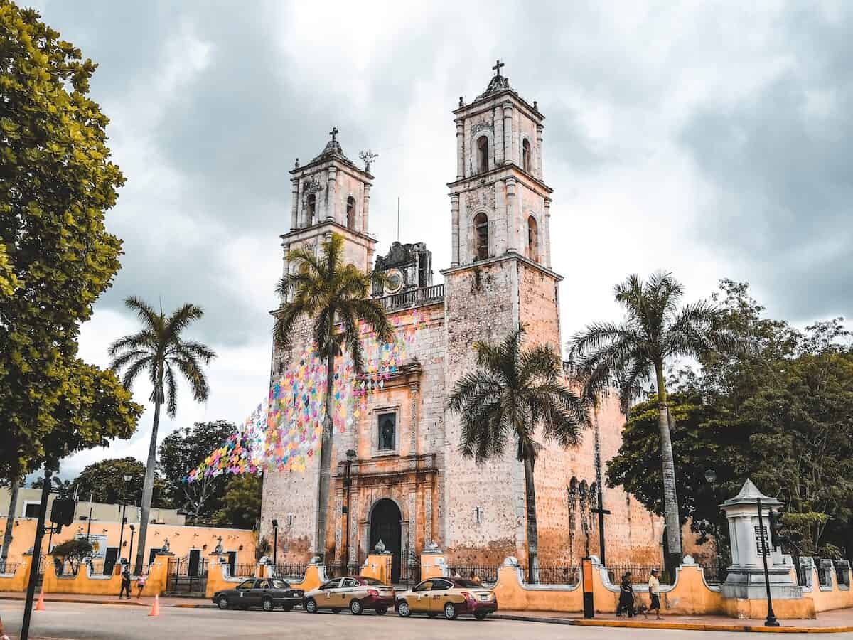 people walking on street near white concrete church in valladolid during daytime