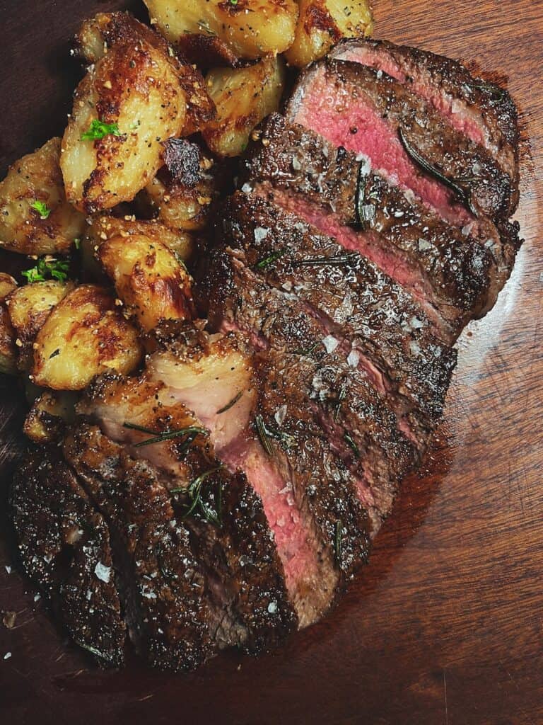 steak and potatoes on brown wooden table