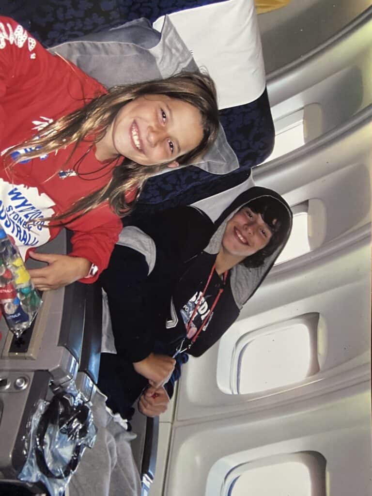 young girl and boy sitting in airplane seats