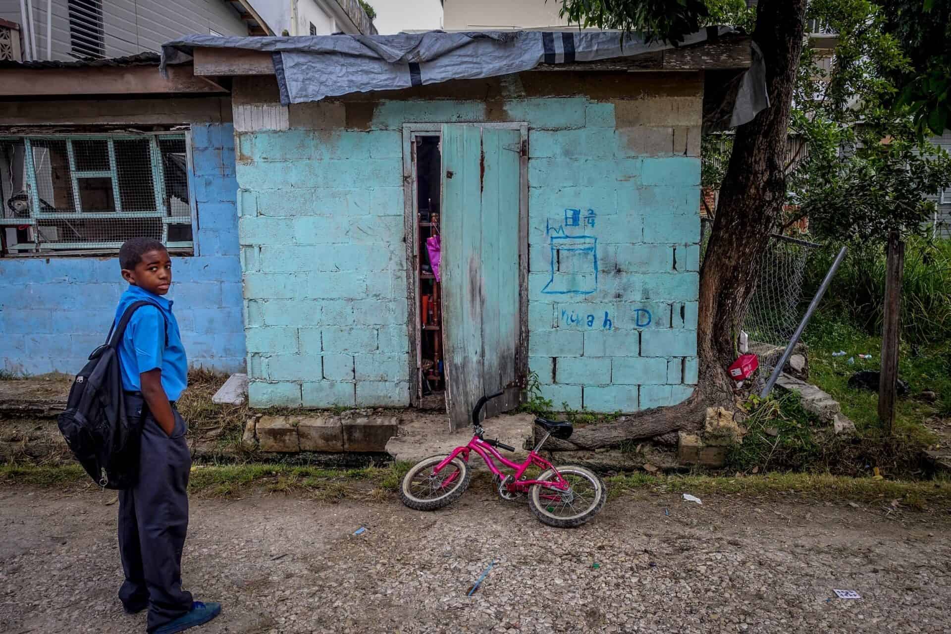 child standing near run down shack