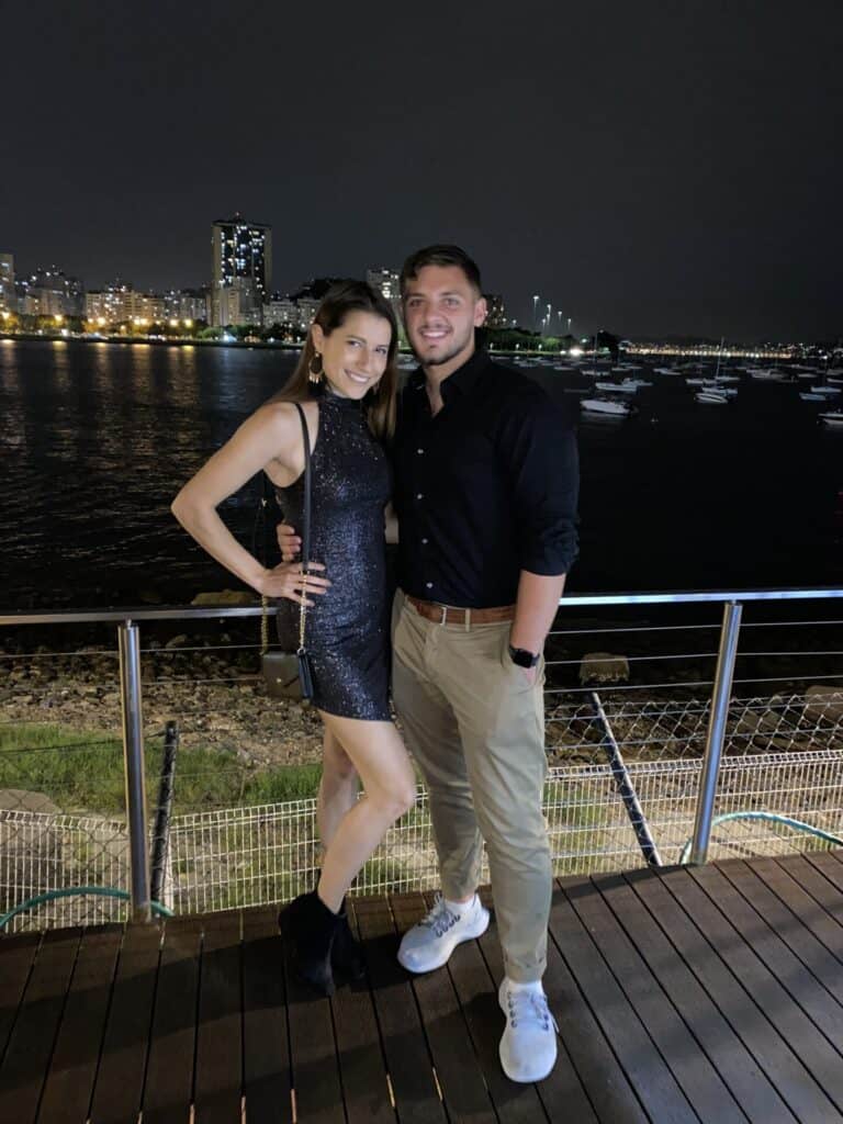 elegant couple dressed up in black posing in front of city